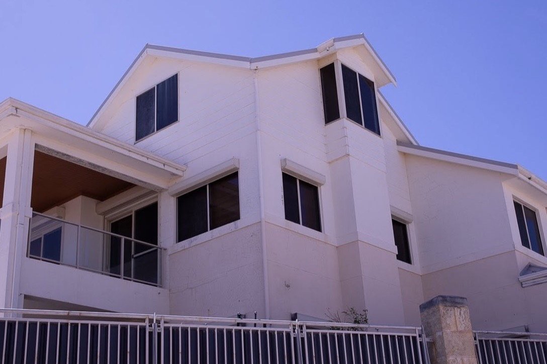 Faded, dirt-streaked render on a two-storey Perth home before an exterior repaint