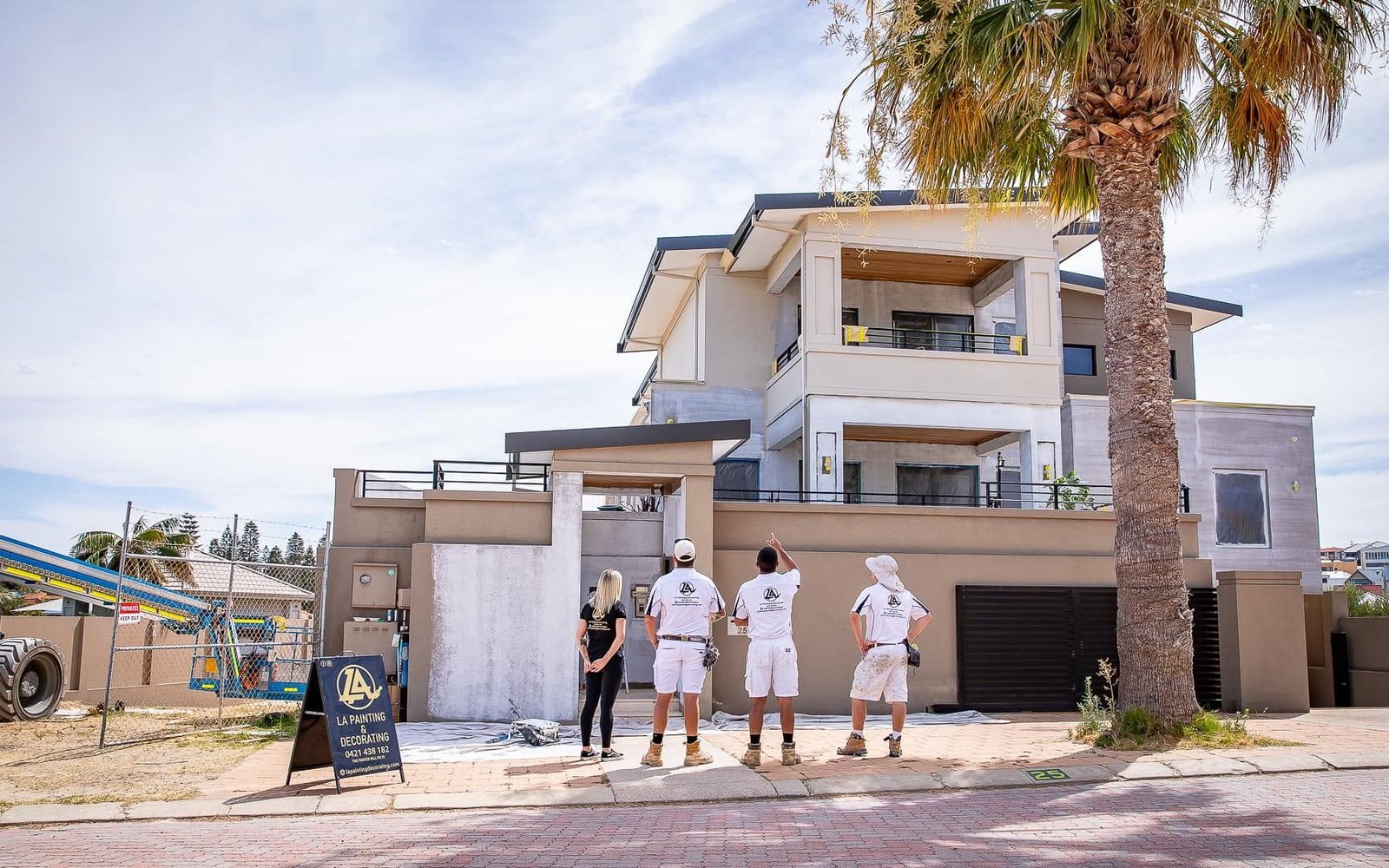 LA Painting & Decorating team inspecting and assessing a large rendered Perth home's exterior before preparation and painting