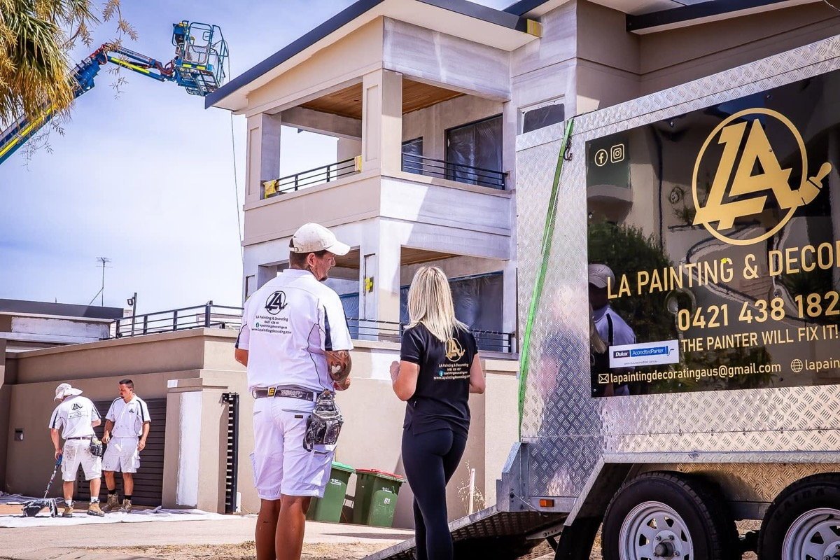 The LA Painting & Decorating team on site at a Perth home with their branded trailer