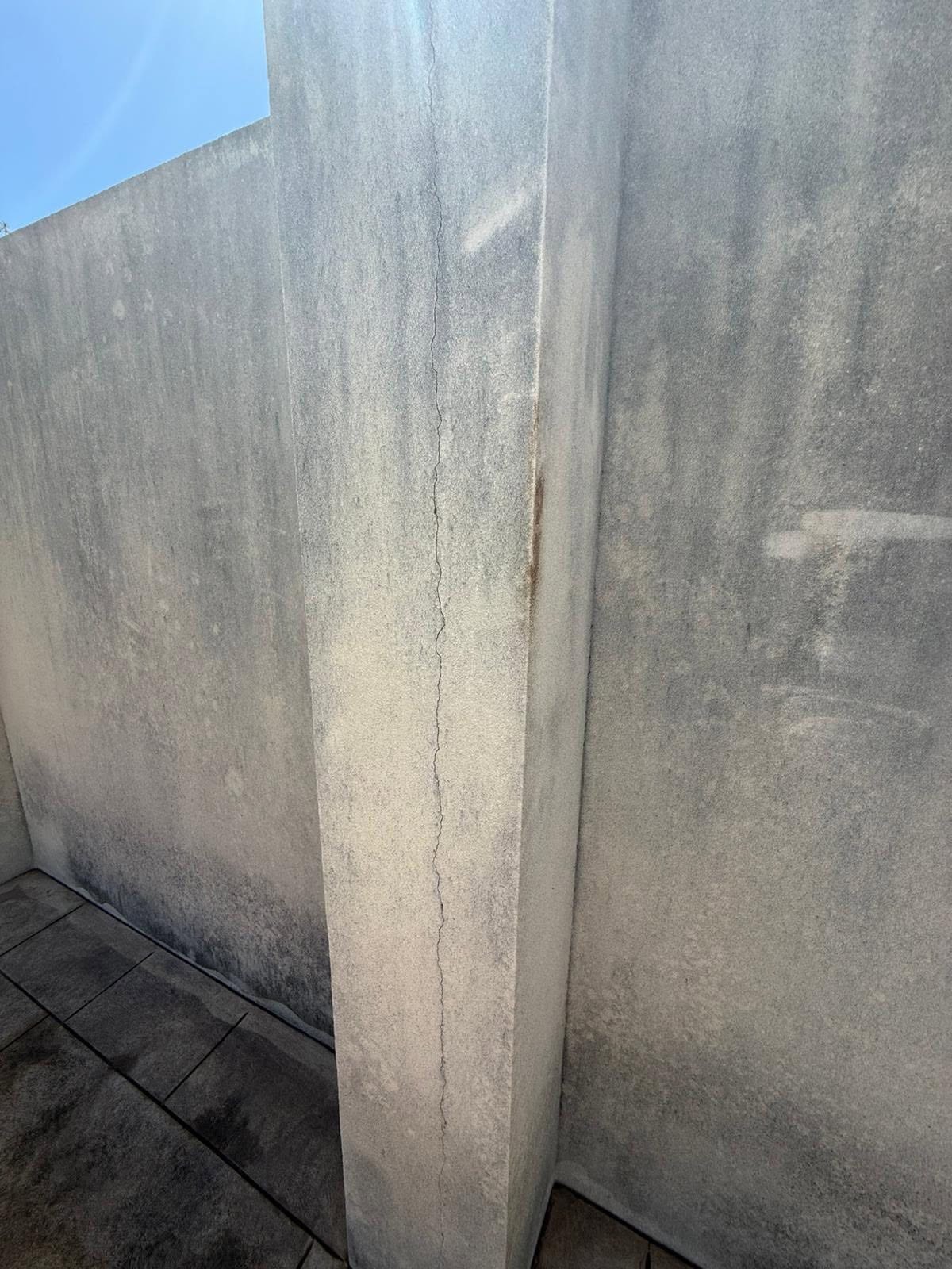 Vertical crack and water staining in weathered render on a Perth exterior wall