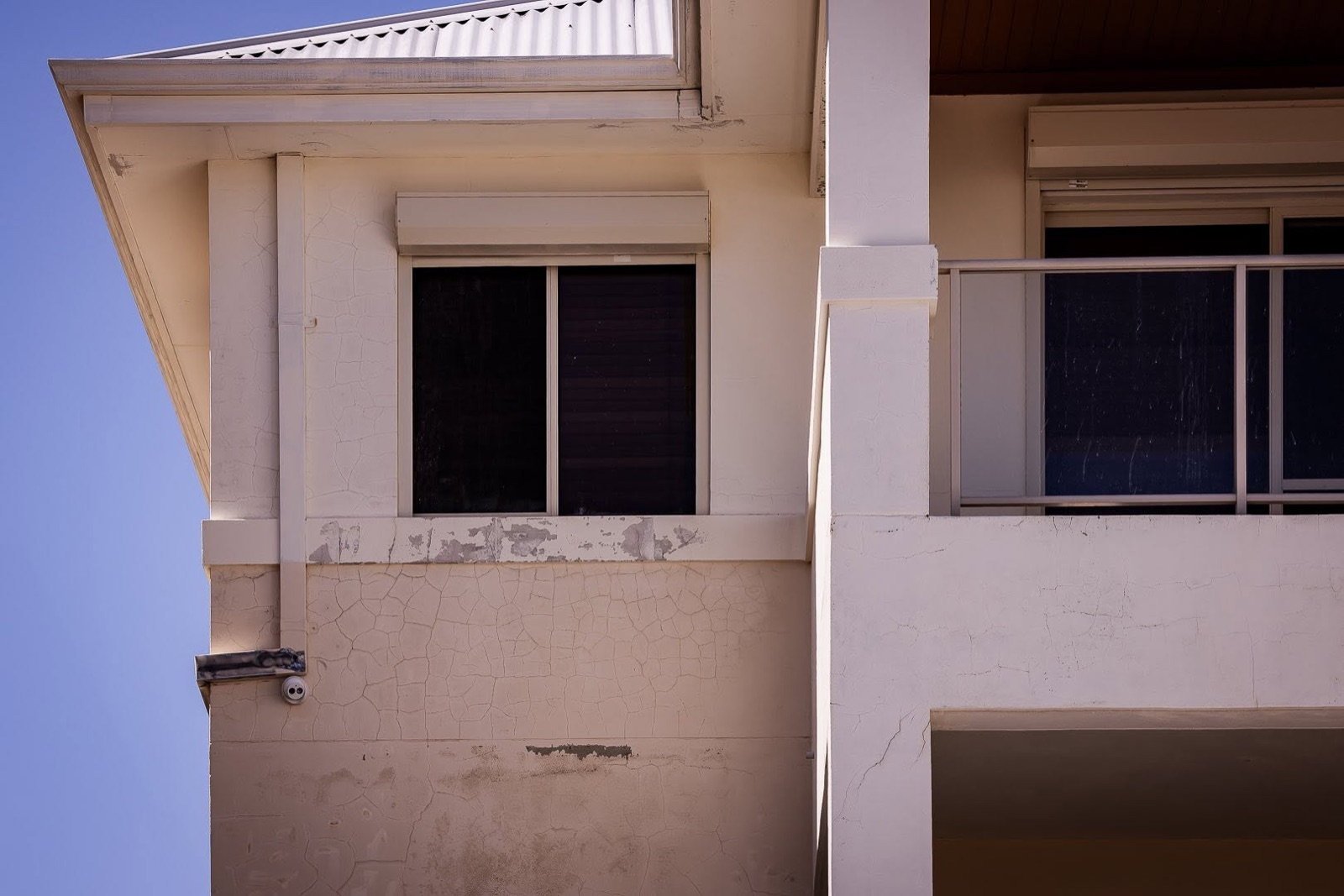 Cracked, crazed render and peeling paint on a Perth home, a clear sign the exterior is due for a repaint